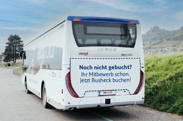 Heckwerbung, © NÖVOG/Grojer Heckansicht eines weißen Reisebusses mit der Aufschrift 'Noch nicht gebucht? Ihr Mitbewerb schon. Jetzt Busheck buchen!'