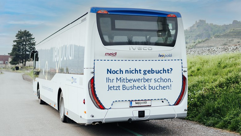 Heckwerbung, © NÖVOG/Grojer Heckansicht eines weißen Reisebusses mit der Aufschrift 'Noch nicht gebucht? Ihre Mitbewerber schon. Jetzt Busheck buchen!'