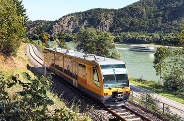 Unterwegs mit der Wachaubahn, © NB/weinfranz Goldener Triebwagen der Wachaubahn fährt entlang der Donau