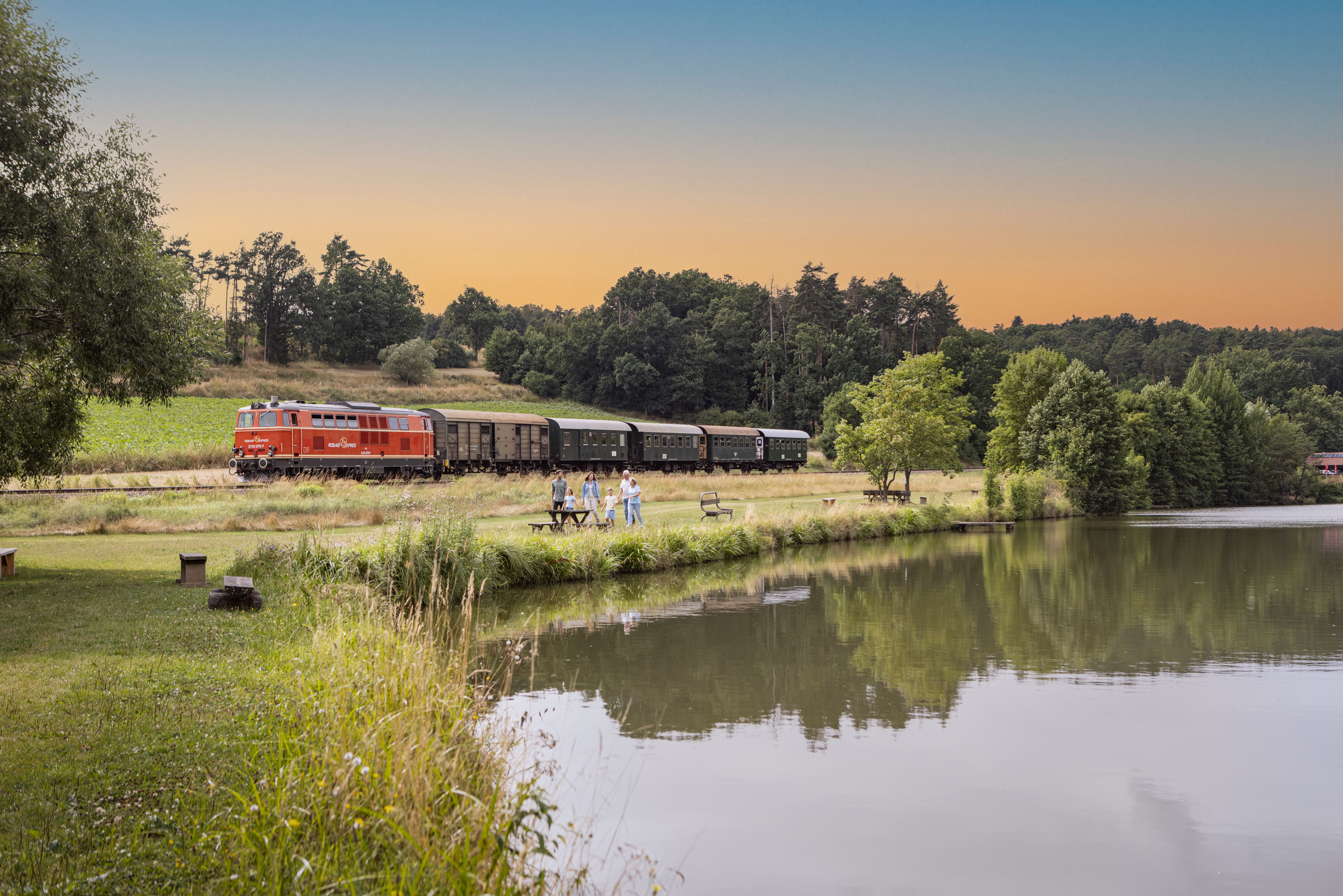 Reblaus Express im Sommer vor einem Teich.